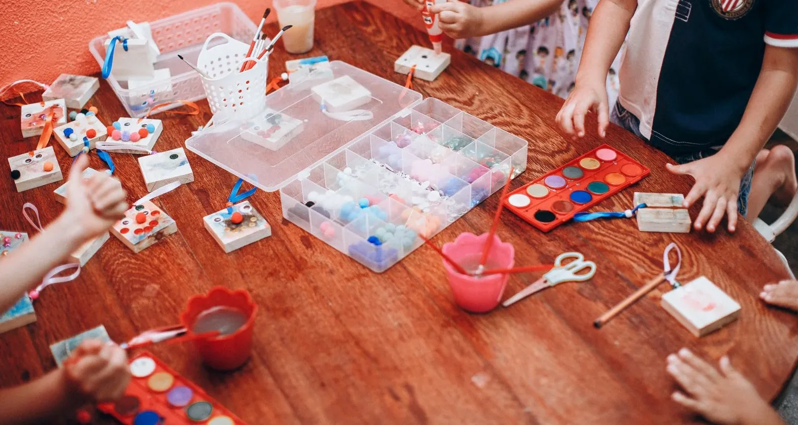 Hands painting and making art around a table
